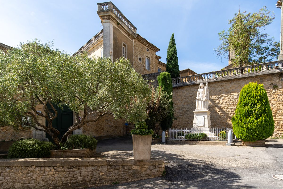 La place du village de Gaujac, son château et ses oliviers